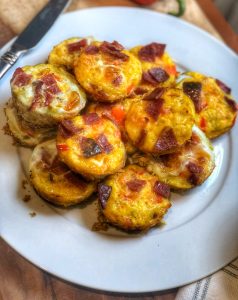 mini sweet potato breakfast quiches on a white plate with a knife on the side