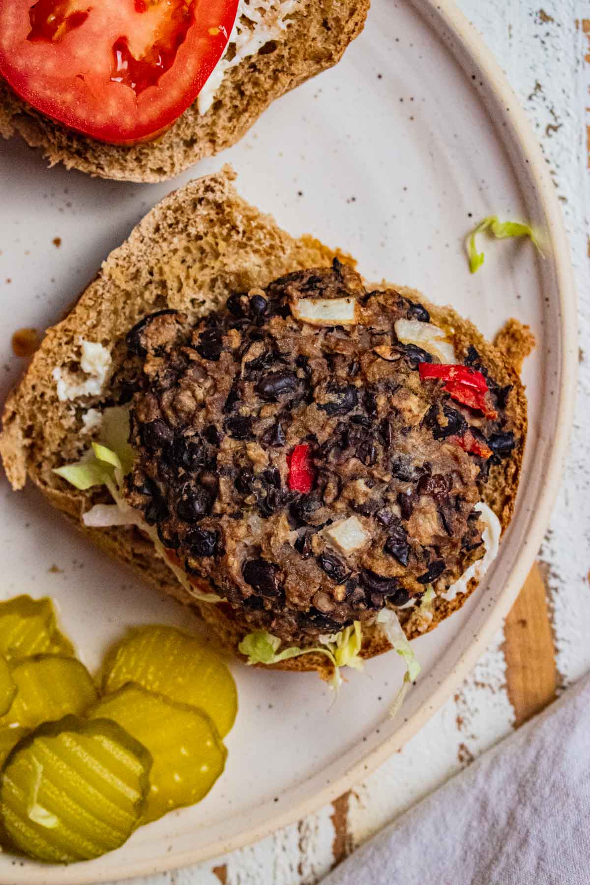 a close up of the easy black bean burgers with a side of pickles