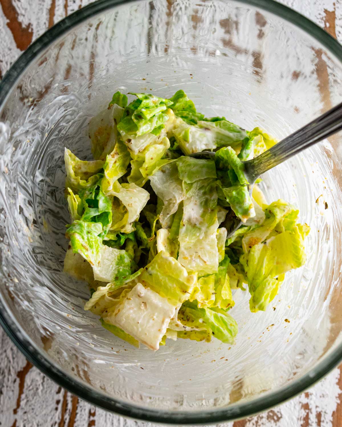 a bowl of romaine lettuce mixed with mayo and seasonings