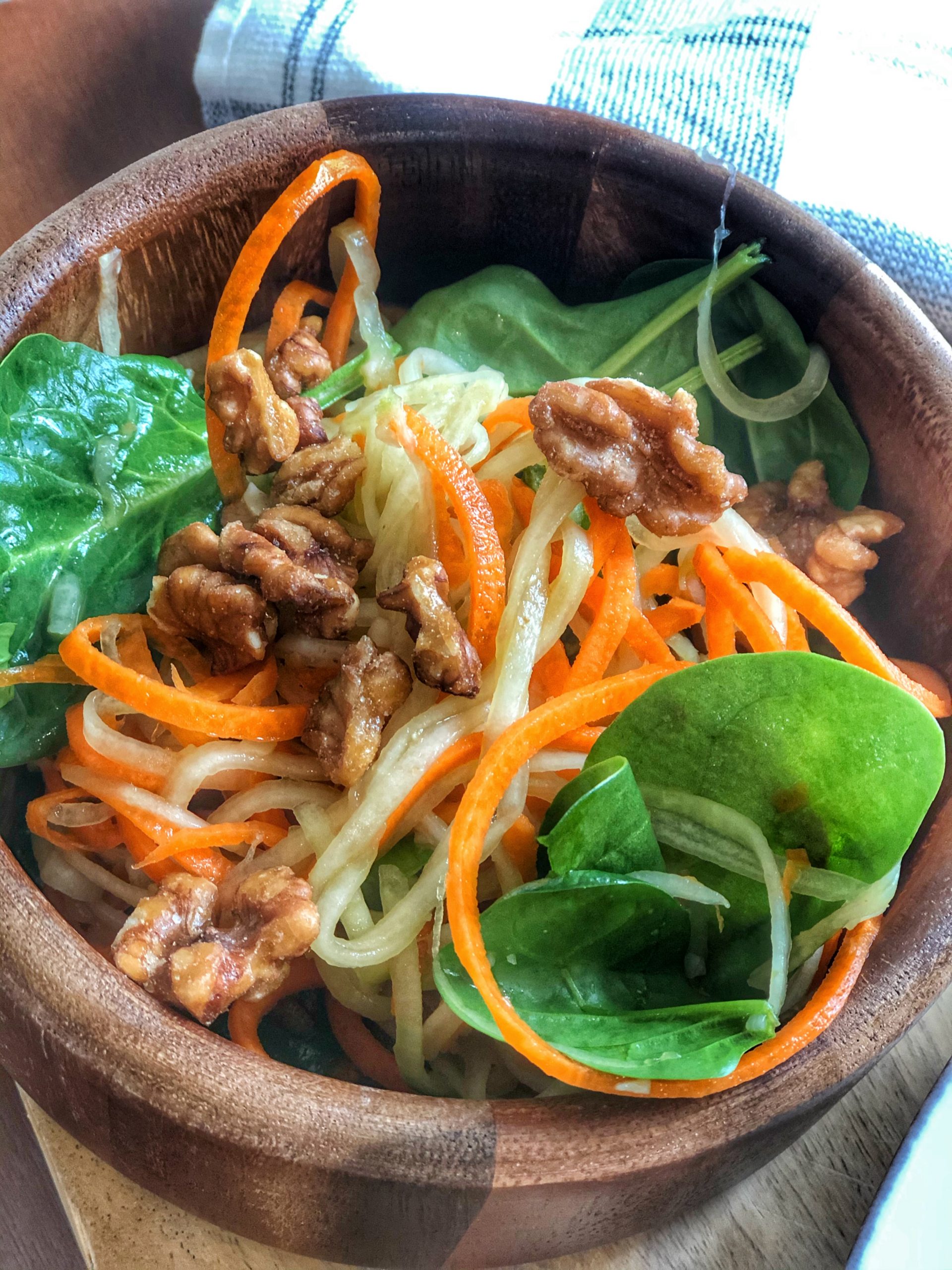 close up of spiralized zucchini and carrots mixed with spinach and walnuts
