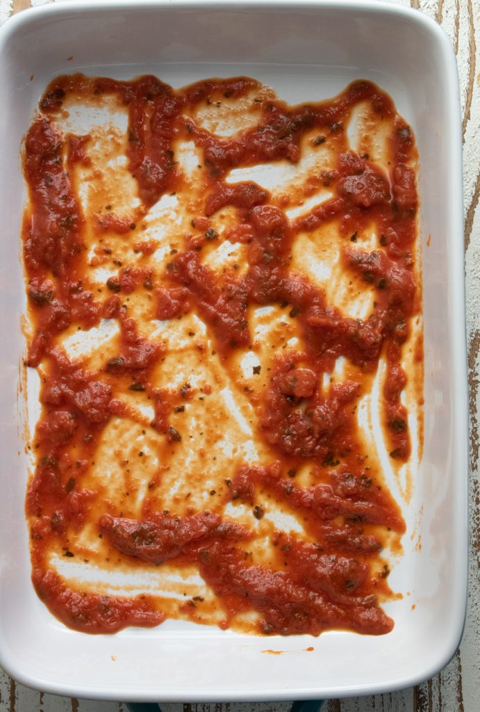 tomato sauce on the bottom of a 9 x 13 inch baking dish