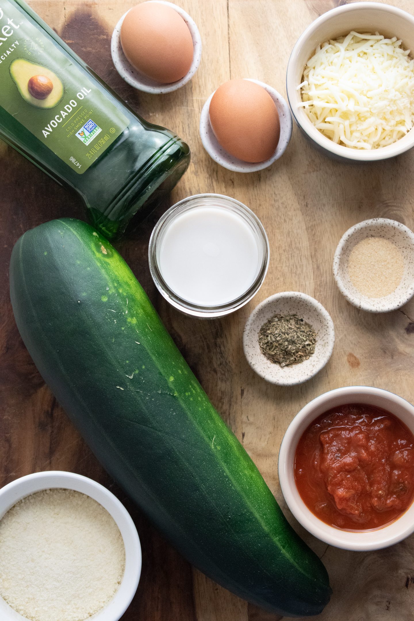 ingredients for zucchini parmesan on a wooden cutting board