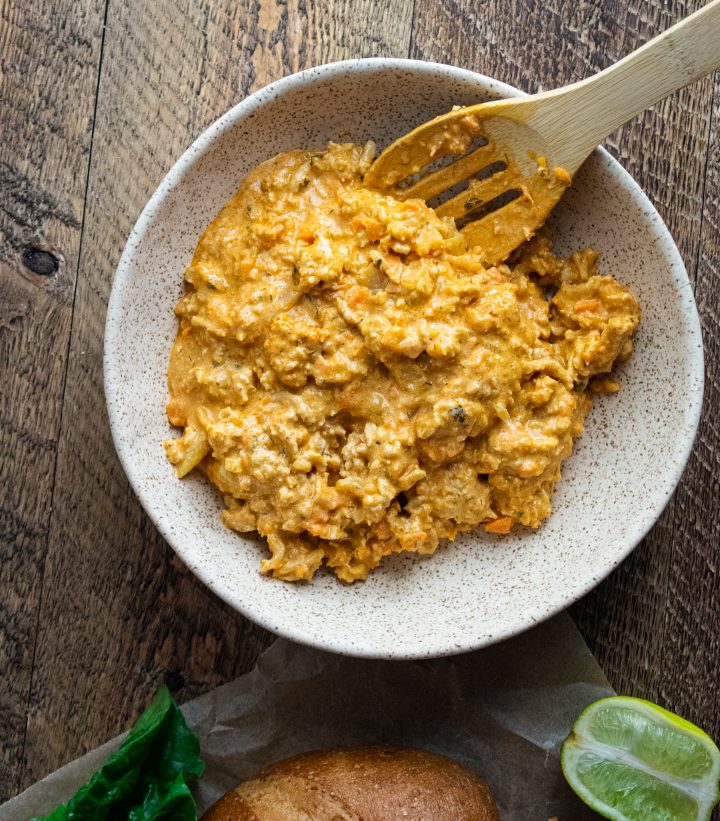 buffalo chicken sloppy joes in a white bowl with a wooden spoon on a wooden board with 