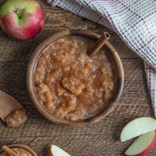 homemade crockpot applesauce in a wooden bowl on a wooden table