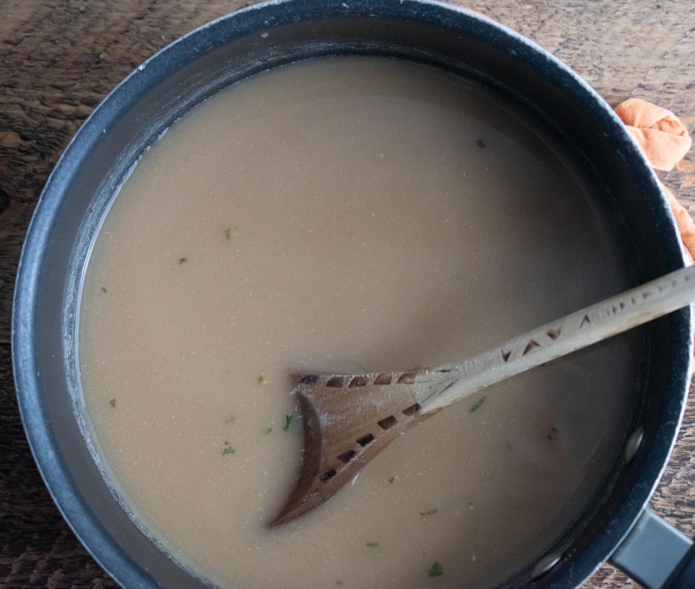 broth almond milk and seasonings being stirred in a medium saucepan