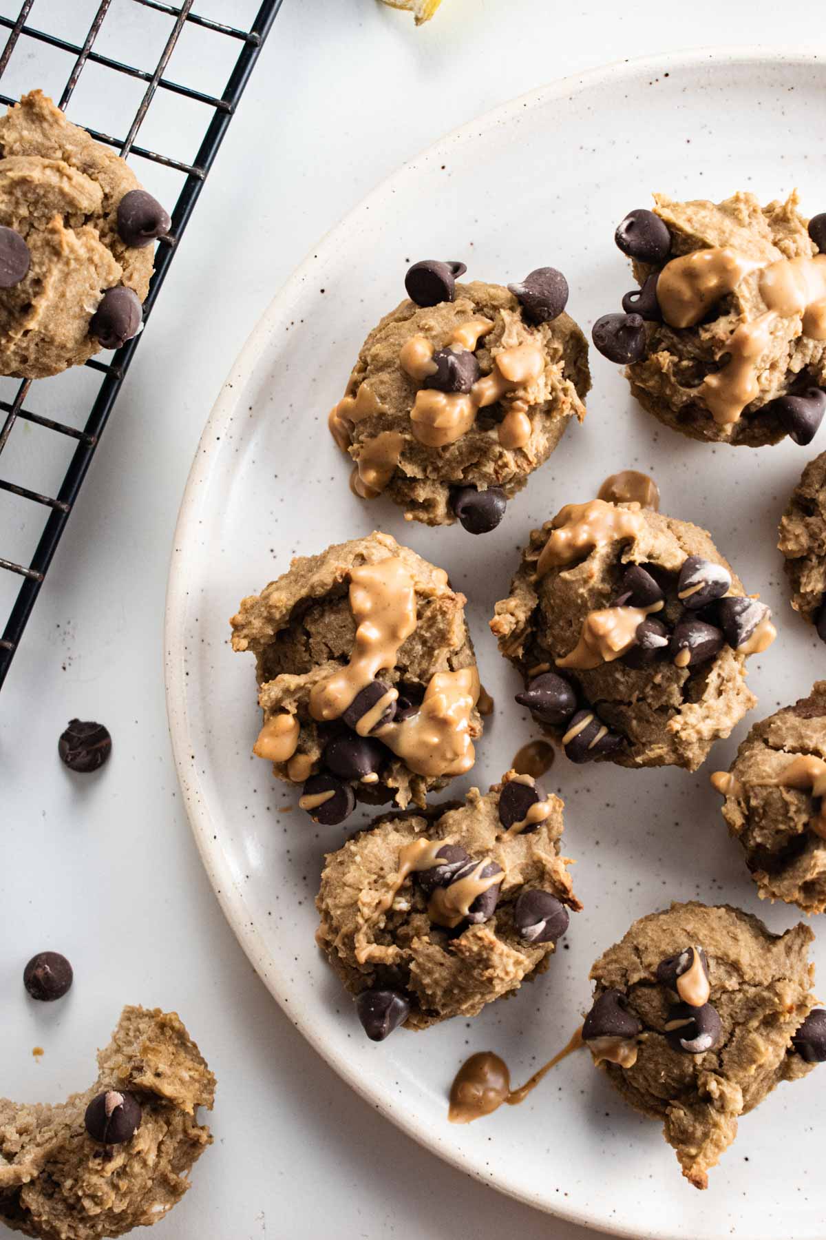 close up of flourless banana muffins topped with chocolate chips on a white plate