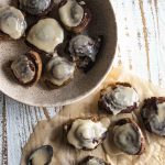 birds eye view of cinnamon buns on pieces of parchment paper and in a white colored bowl