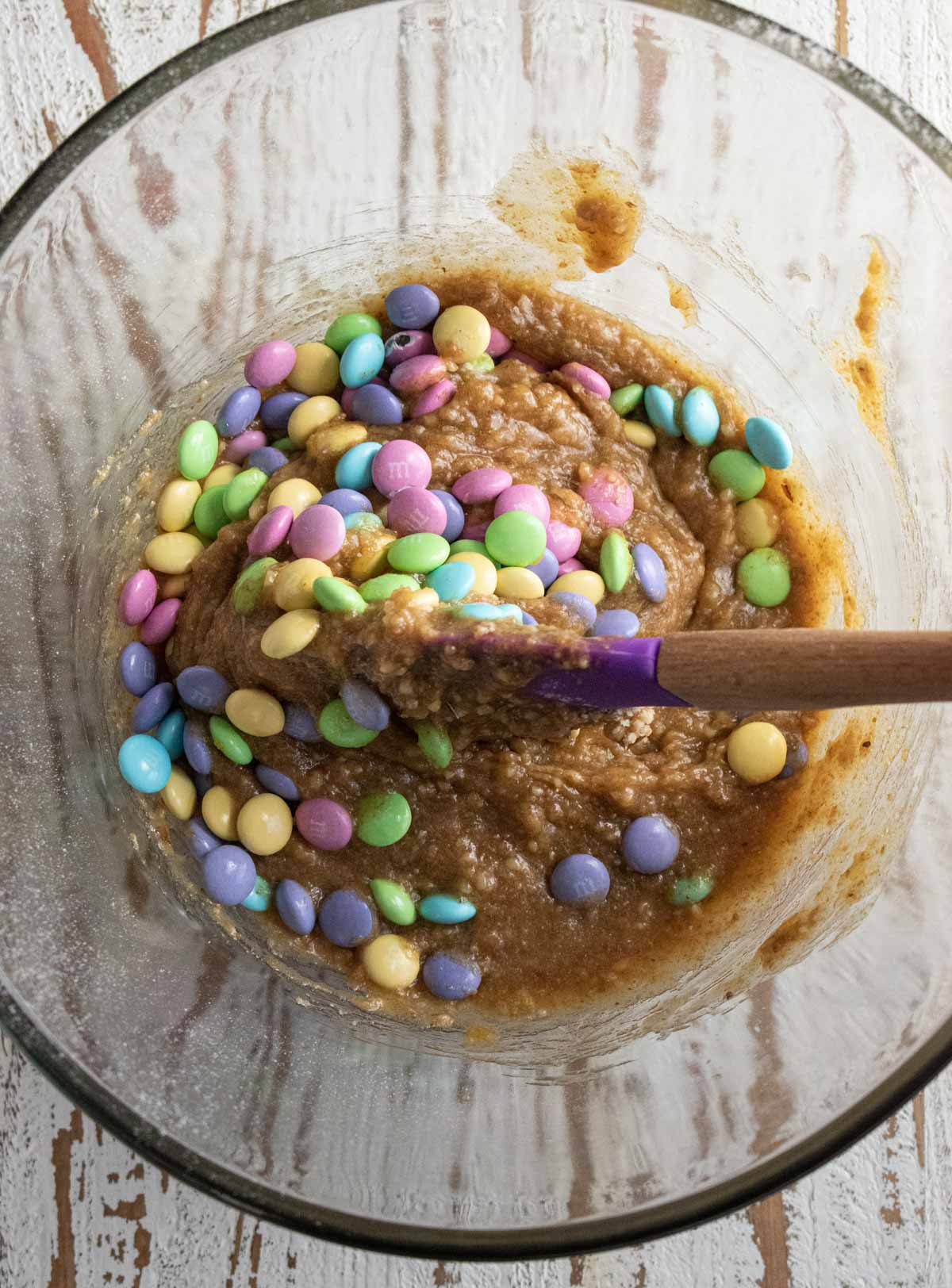 Batter for the blondies being mixed with multi-colored m&ms. Step 4 for this recipe.