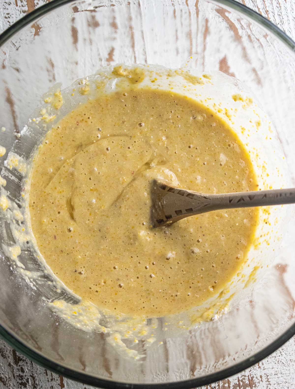 Step 4 of the baking process. A mixing bowl filled with the dry ingredients mixed into the wet ingredients.